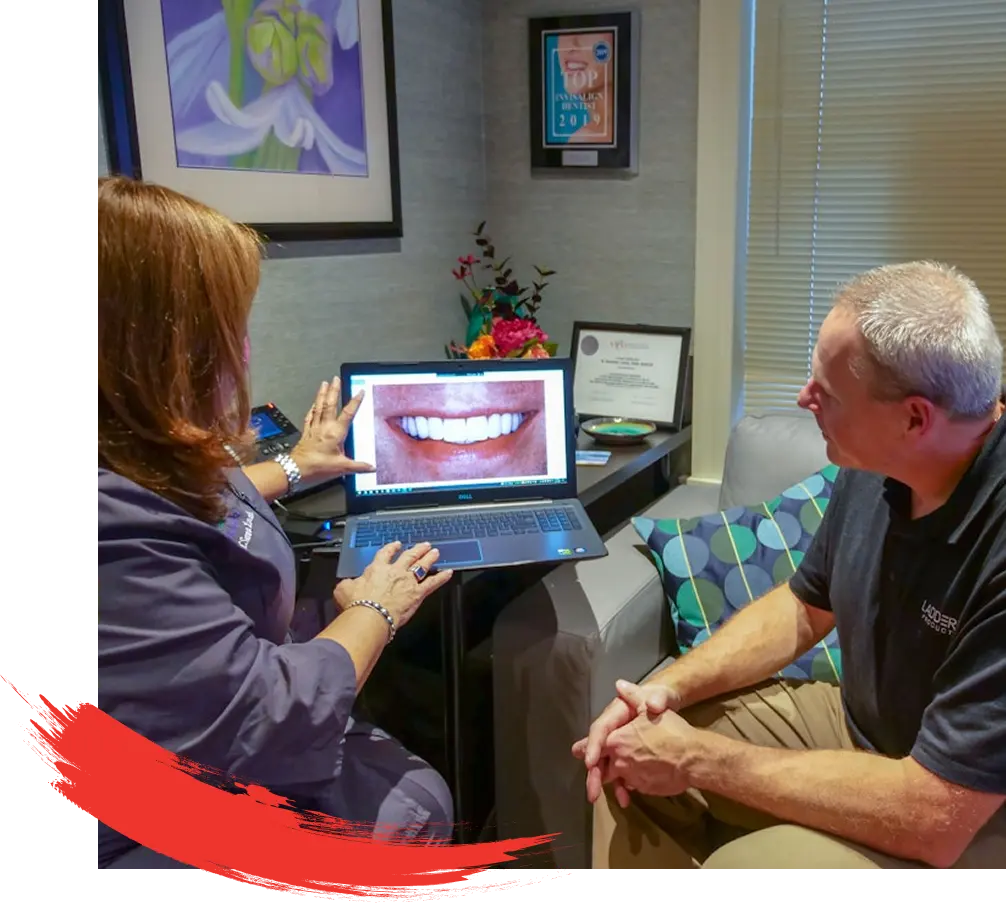 Dr. N. Summer Lerch reviewing dental images on a laptop with a seated patient