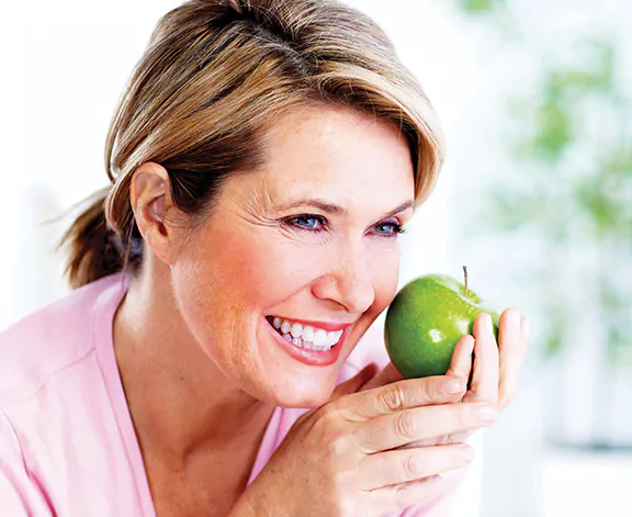 woman holding an apple smiling