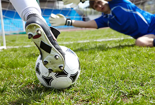 kid kicking a soccer ball