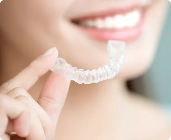 woman holding an aligner