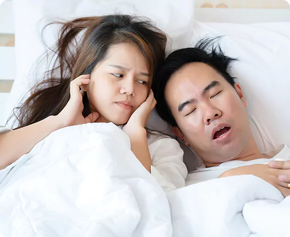 two people in bed, one snoring