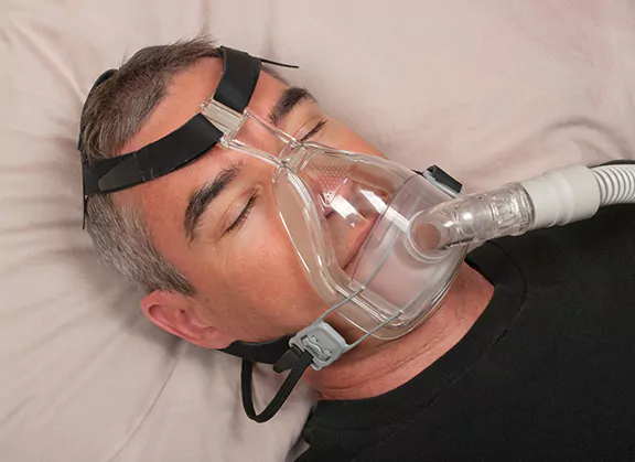 man with sleep apnea machine on