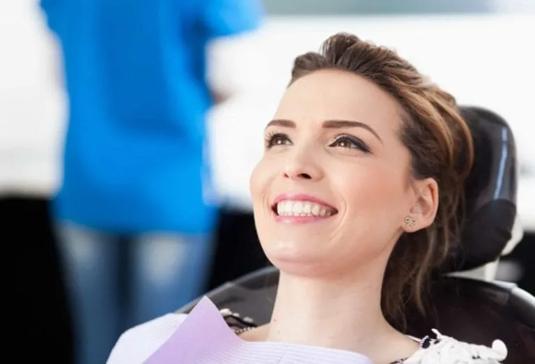 Smiling woman reclined in a dental chair during an appointment