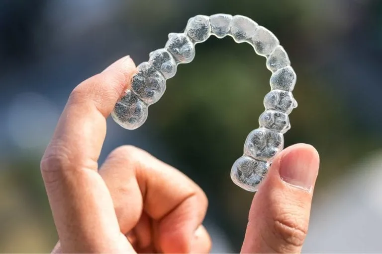 Hand holding a clear aligner tray