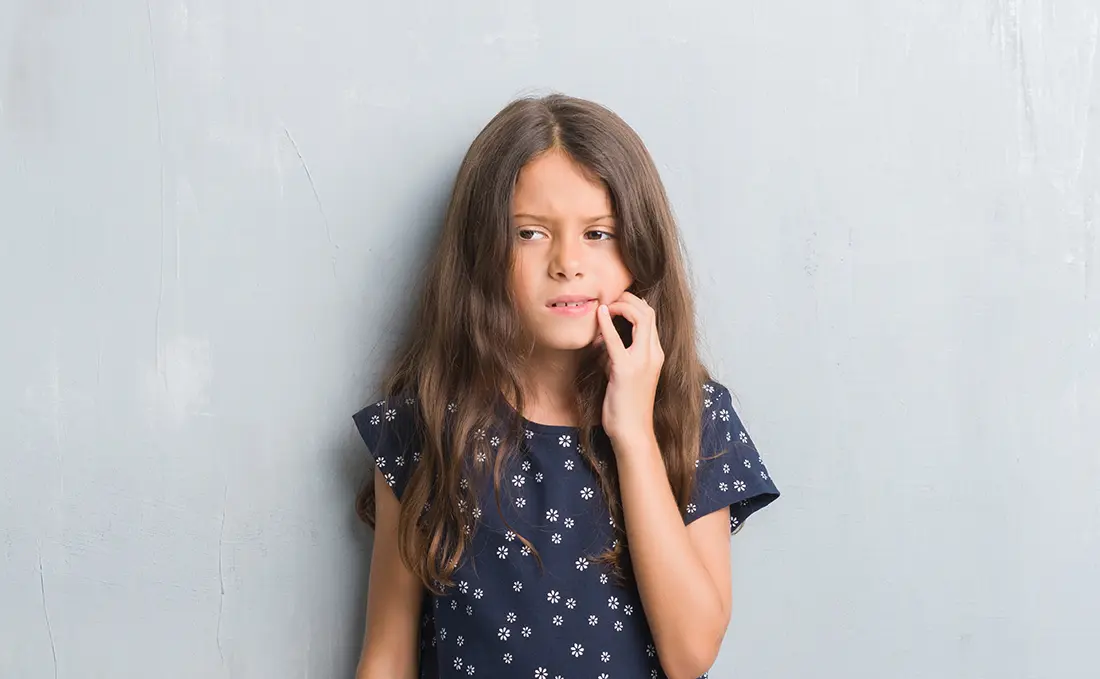 Child holding her jaw in discomfort