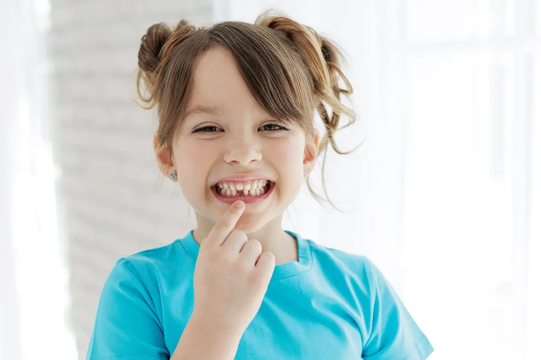 Child pointing to spot where tooth used to be