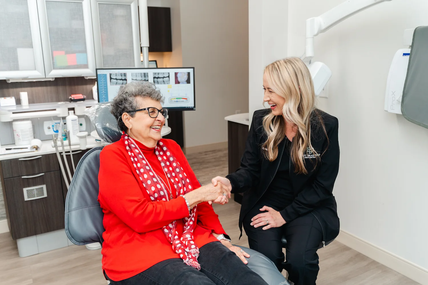 woman and hygienist smiling