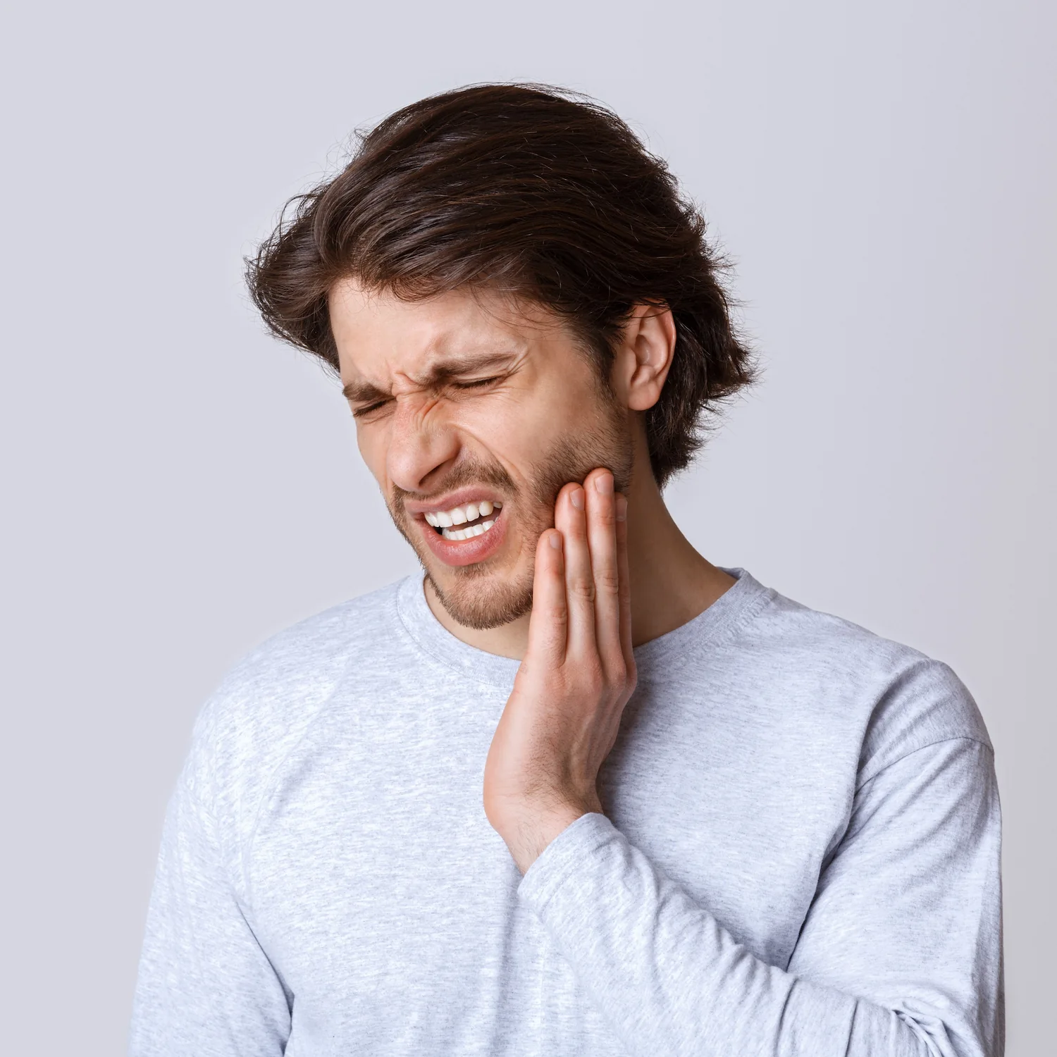 man holding jaw in pain